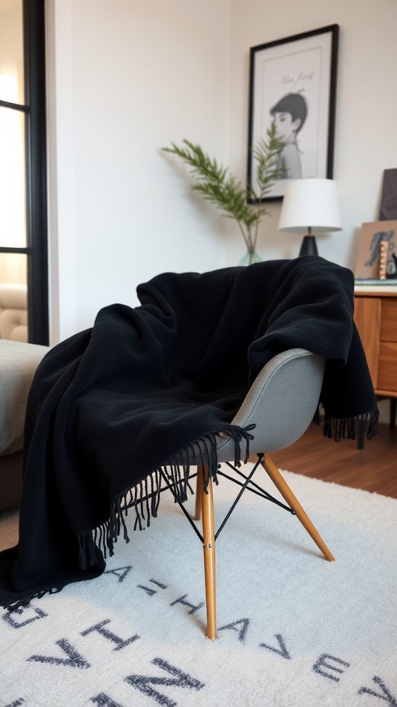 A stylish black throw blanket draped over a modern chair in a cozy bedroom setting.